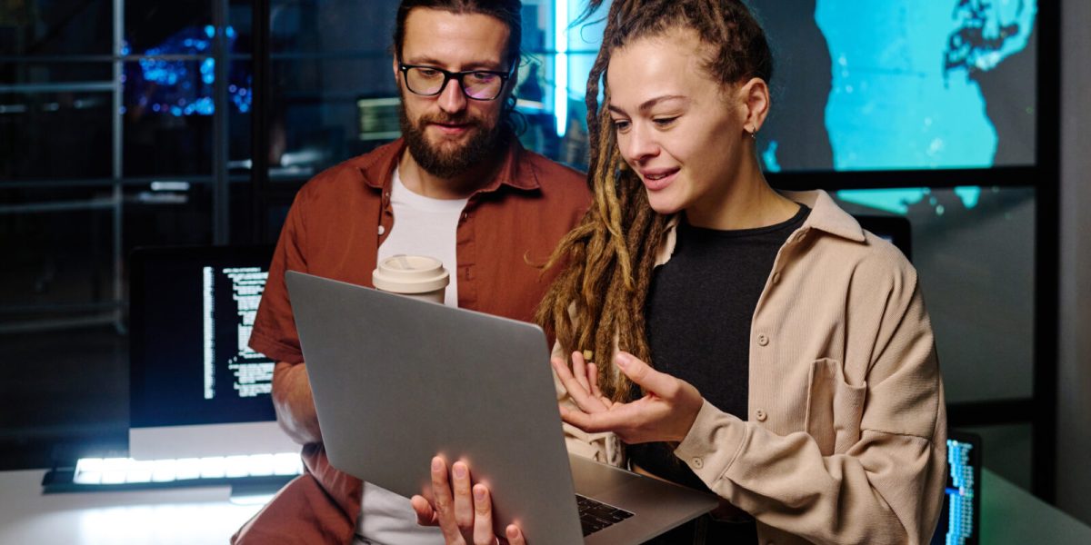 Young confident woman explaining online data to male colleague